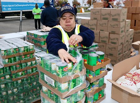 Volunteers help sort canned goods before the event started Wednesday morning at WHC Lemoore.